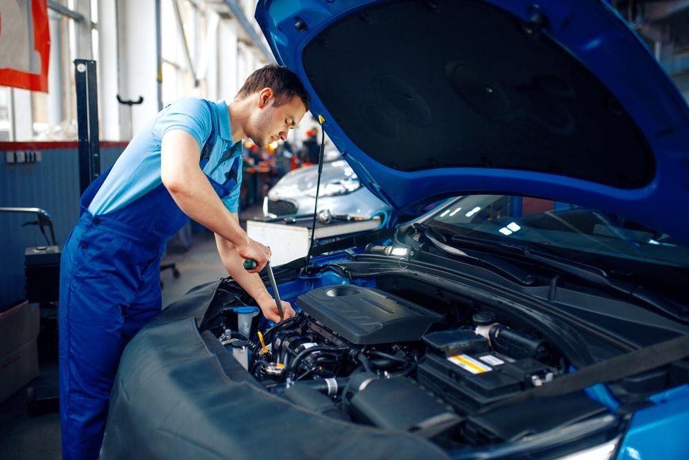 Técnico dando servicio al motor de un vehículo